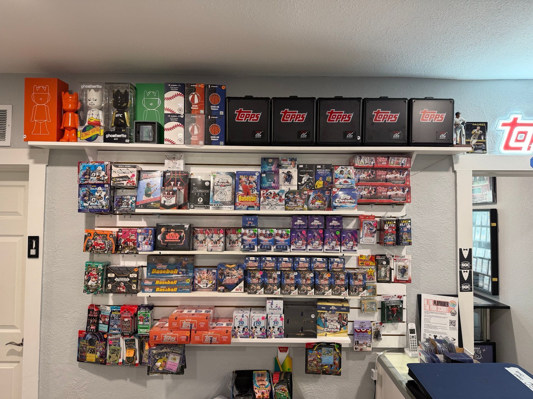 A wall of sealed card boxes under a row of Topps boxes
